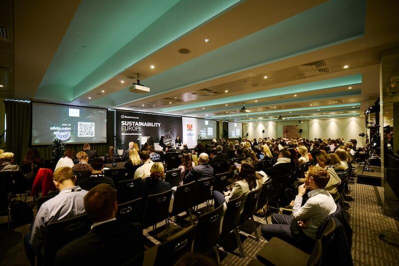 A room full of people watching a presentation.