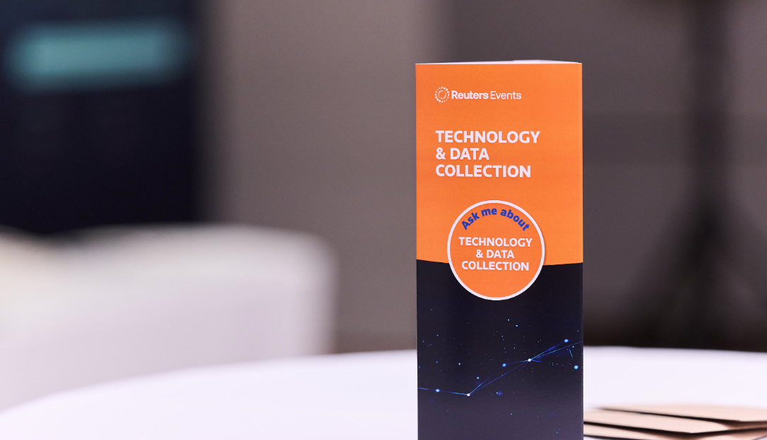 A Reuters Events "Technology & Data Collection" branded brochure standing upright on a table at the Sustainability Europe conference.