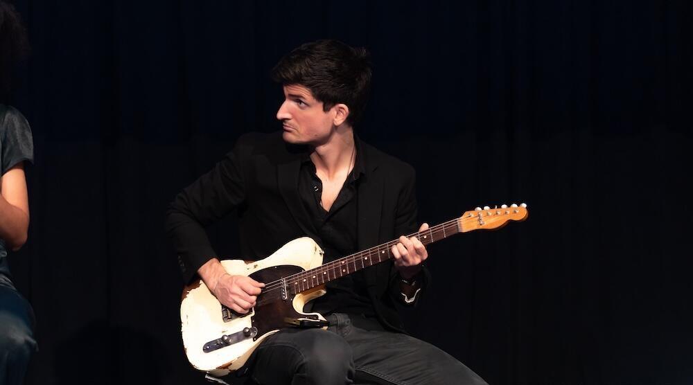 A person on stage holding a guitar
