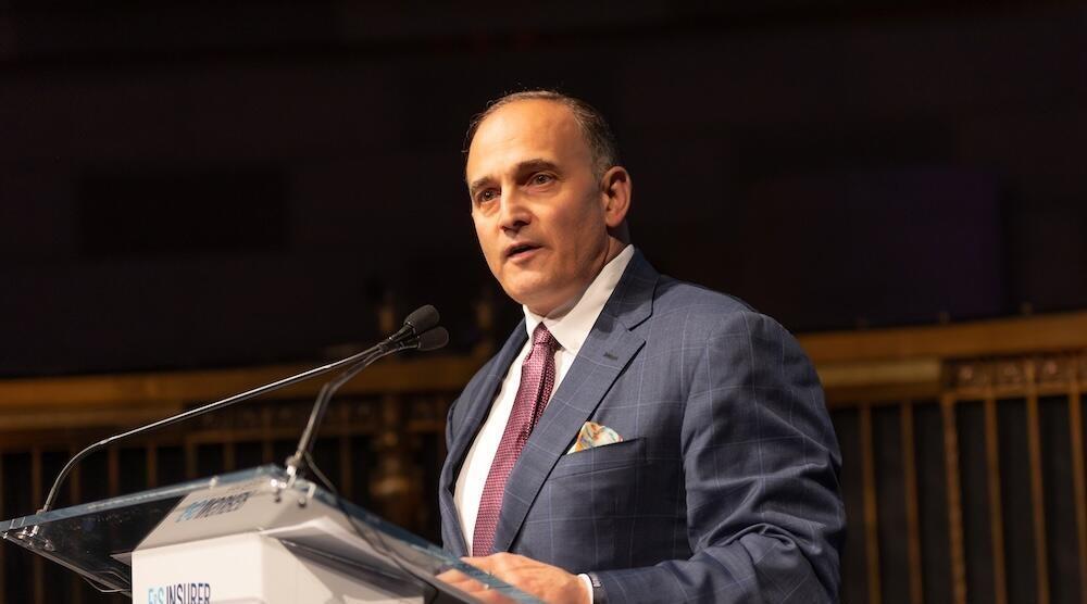 A person on stage talking into a mic at a podium