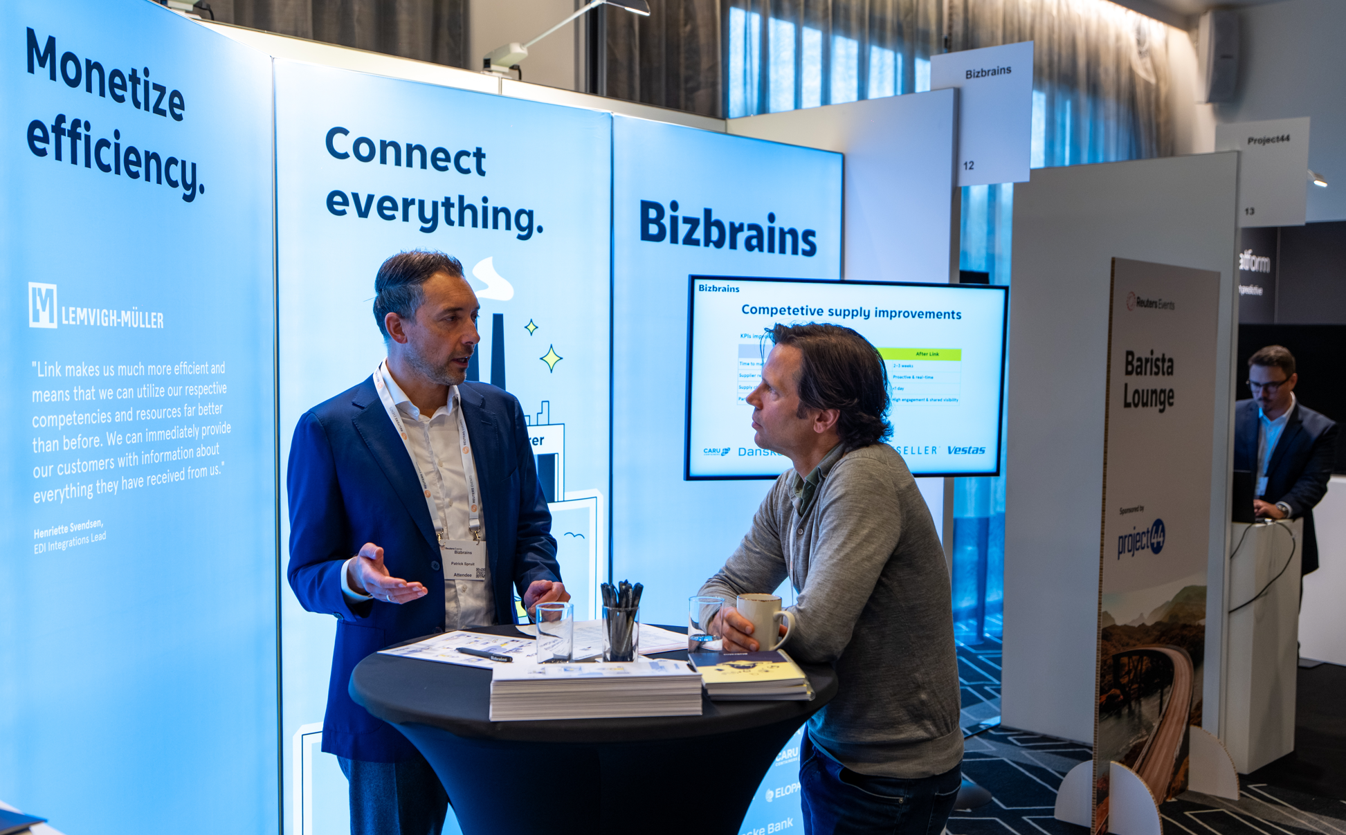 Two attendees talking at a Bizbrains trade show booth.