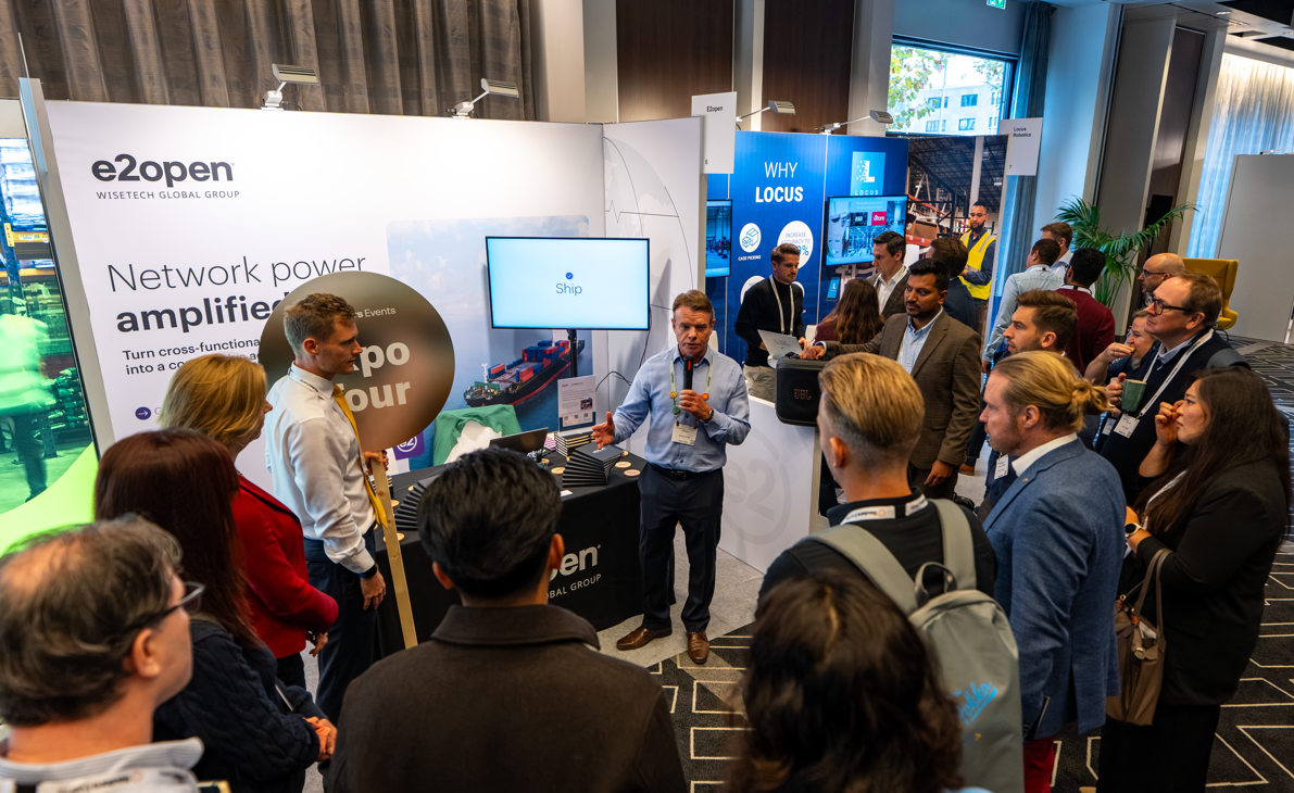 Attendees gathered around a speaker at the e2open expo booth.