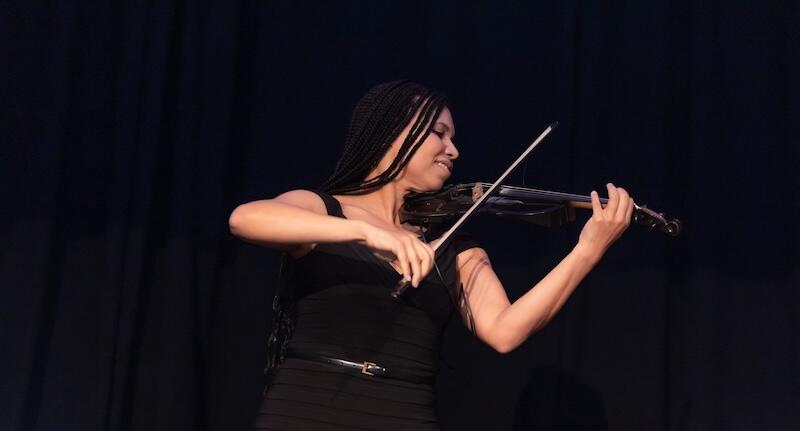 A person on stage holding a violin