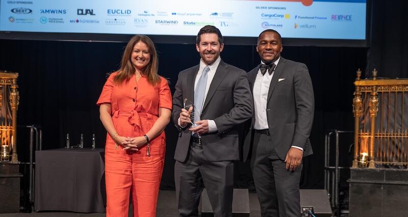 Two presenters posing with an award winner