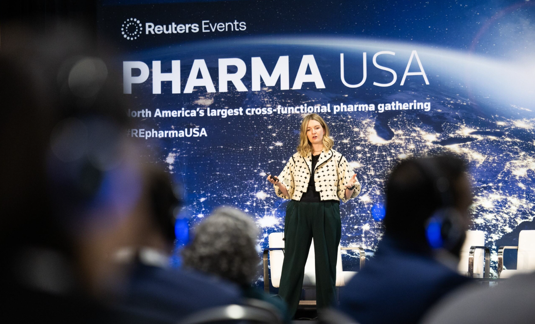 Speaker onstage at Pharma USA, mid-presentation