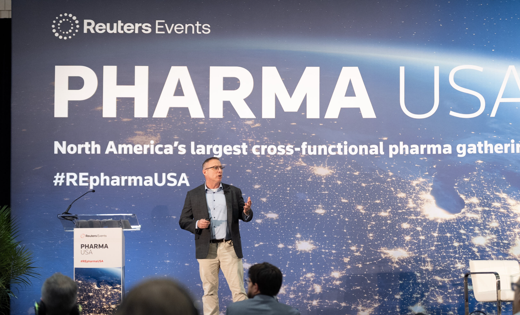 Speaker onstage at Pharma USA, mid-presentation