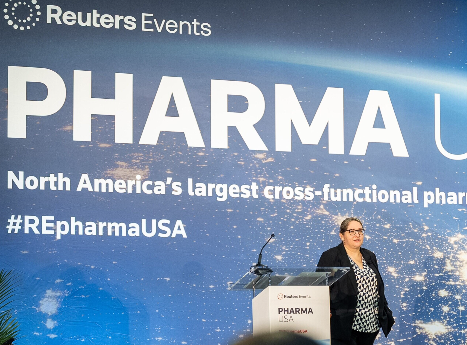 Speaker onstage at Pharma USA, mid-presentation