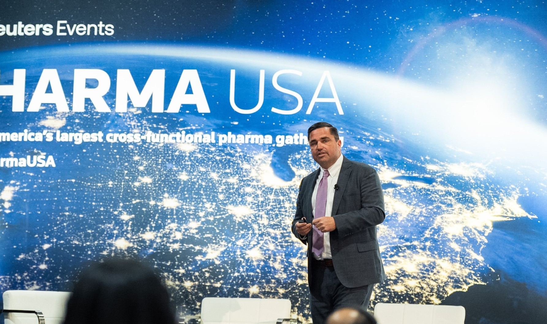 Speaker onstage at Pharma USA, mid-presentation