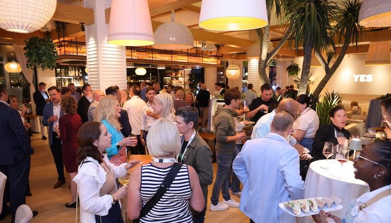 Attendees at a Reuters Event gathered in a large hall during a networking party