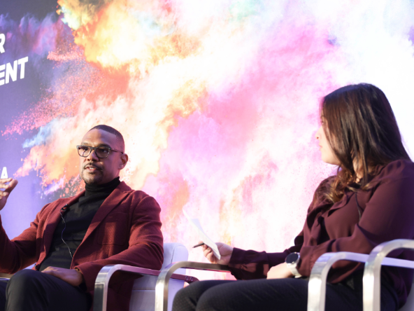 2 speakers onstage at a Reuters Event, mid conversation